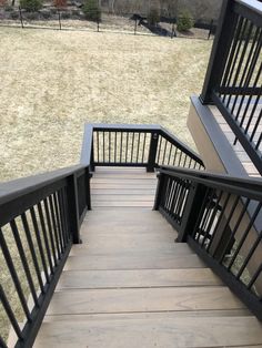 the stairs lead up to an open grassy field