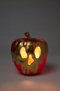 an orange pumpkin with glowing eyes on it's face is shown in front of a gray background