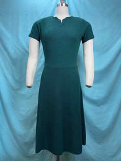 1940s/1950s W:30"+ knit stretch dark green dress short sleeves V neckline boucle a-line skirt  Vintage 40s/50s Beautifully constructed vintage 40s/50 dress. Fully knitted dark green boucle , short sleeve with a notched V neckline and A-line skirt. Pull over style with hook and eye in the back. Very original design. Photographed on fit form size 8, check measurements.  MEASUREMENTS  Knitted dress, has possibility of stretch about +2/3" Bust: 36"+ Waist: 30"+ Hips: 42" Bodice length: 18" Skirt len Dark Green Dress Short, Green Dress Short, 50 Dress, Dark Green Dress, Dress Short Sleeves, Vintage 40s, Skirt Vintage, Knitted Dress, 50s Fashion