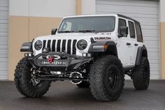 a white jeep parked in front of a building