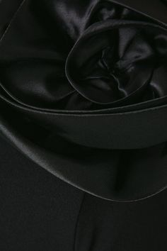 the back side of a black suit with a tie