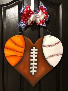 a door hanger with a football, basketball and heart shaped ornament on it