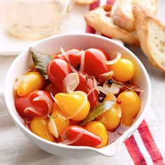 a white bowl filled with lots of tomatoes