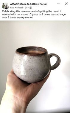 someone is holding up a cup that looks like it has been made out of clay