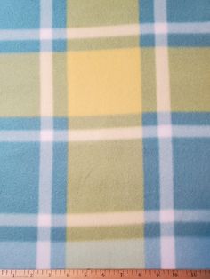 a blue and yellow plaid fabric with a ruler