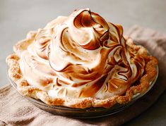 a pie with whipped cream on top sitting on a table