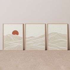 three framed art prints on a wall above a bed in a room with beige walls