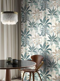 a table and chair in front of a wallpapered room