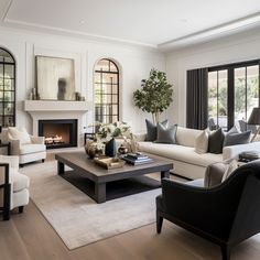 a living room filled with furniture and a fire place in the middle of a room