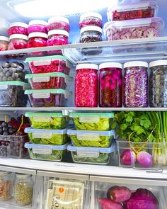 an open refrigerator filled with lots of different types of vegetables and food in plastic containers