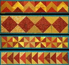 three rows of red and yellow quilts with different designs on them, one has an arrow in the middle