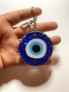 a hand holding a blue evil eye keychain