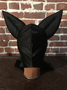 a black cat mask on top of a wooden table