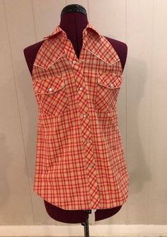 a mannequin wearing a red and white checkered shirt on top of a dummy