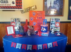 a blue table topped with lots of pictures and decorations next to a dog themed sign