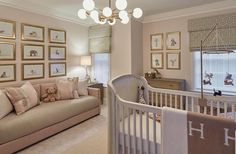 a baby's room with a couch, crib and pictures on the wall