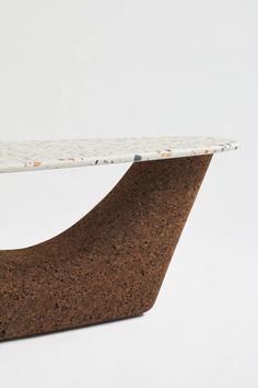 a white and brown table sitting on top of a wooden base with a marble top