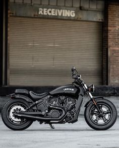 a black motorcycle parked in front of a building