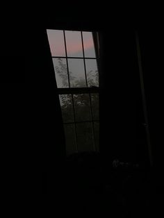 a window in a dark room with trees outside