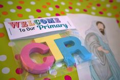 plastic letters and magnets are sitting on a polka dot tablecloth with the words welcome to our primary