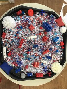 a black tray filled with red, white and blue sprinkles