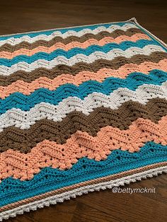 a crocheted blanket is laying on the floor