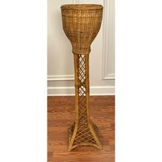 a tall wicker candle holder on the floor