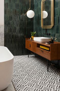 a white bath tub sitting next to a wooden cabinet in a bathroom under a mirror