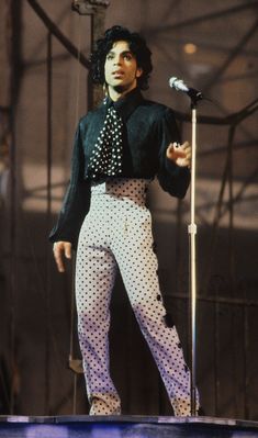 michael jackson performing on stage in front of a microphone with polka dot pants and black shirt