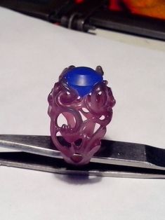 a purple ring sitting on top of a pair of scissors