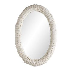 a round mirror with white beads hanging on the wall