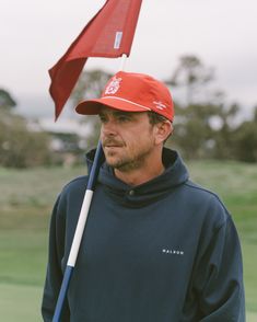 a man with a red hat holding a golf club