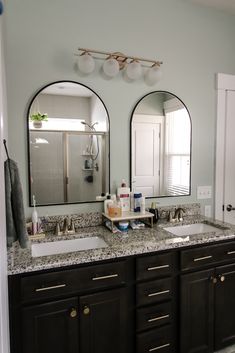 a bathroom with double sinks and two mirrors