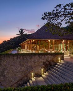 an outdoor area with steps leading up to a pavilion at dusk, lit by lights