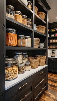 an organized pantry with lots of food in glass jars and baskets on the shelves, along with wooden flooring