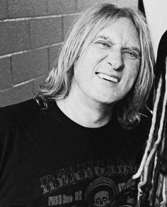 a black and white photo of a man with dreadlocks