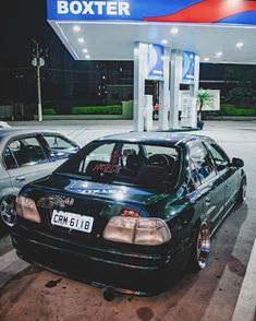 two cars parked in front of a gas station