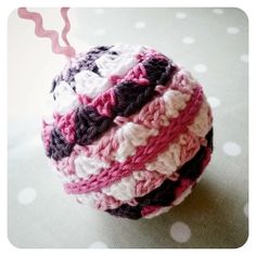 a crocheted ball sitting on top of a polka dot tablecloth covered floor