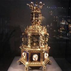 an elaborate clock is on display in a glass case