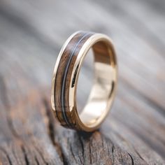 a gold ring with black wood inlays