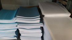 stacks of folded papers sitting on top of each other in front of a printer machine