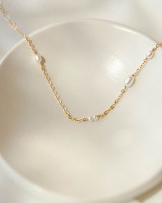 A playful take on a timeless classic—because some pearls just wanna have fun. Each tiny freshwater pearl is organically placed along our sparkliest chain (but fixed in place so they won't slide)! Style it solo or pair with our Floating Pearl Bracelet for a full ethereal look. As with any pearl piece, we recommend avoiding harsh cleansers and beauty products, wearing them often, storing in linen or cloth (no airtight containers) and gently wiping to clean. For more pearl care tips, see our journa Floating Pearl Necklace, Airtight Containers, Recycled Gold, Pearl Chain, Care Tips, Gold Material, Real Gold, Timeless Classic, Pearl Bracelet