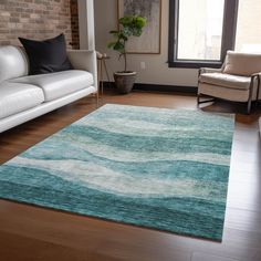 a living room filled with furniture and a large rug on top of a hard wood floor