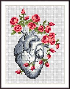 a cross stitch heart with flowers on it