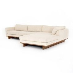 a white sectional couch sitting on top of a wooden table