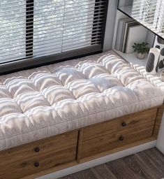 there is a bed with drawers underneath the window