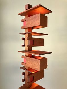 a sculpture made out of wood and lit up with red light coming from the top