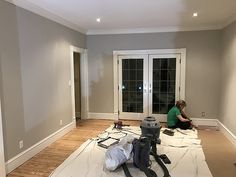 a person sitting on the floor in an empty room with tools and supplies around them