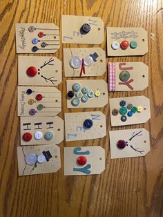 several pieces of paper with buttons attached to them on a wooden table next to scissors