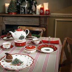 a table set for christmas with plates and cupcakes